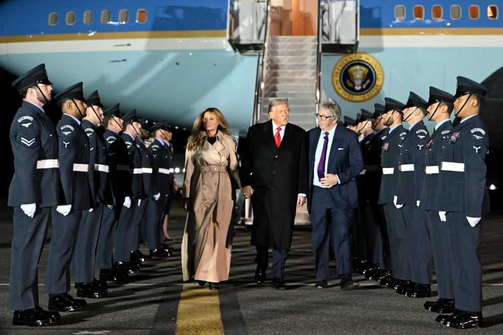 US President Donald Trump (C) and US First Lady Melania Trump disembark from Air Force One after landing at Stansted Airport, eastern England, on September 16, 2025. (Photo by Andrew Caballero-Reynolds / AFP)