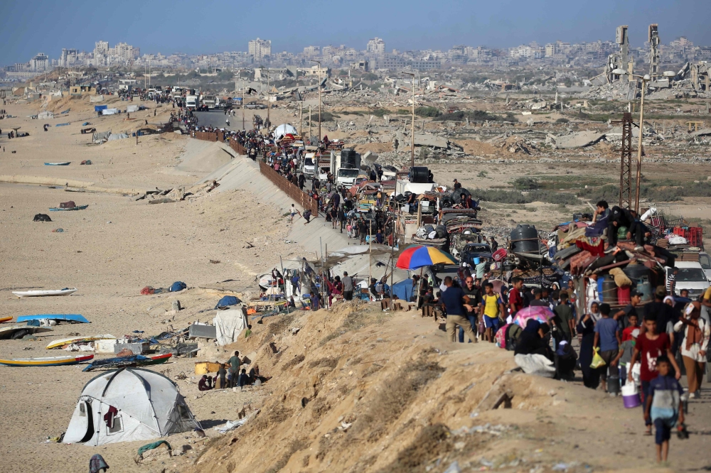 :Displaced Palestinians move with their belongings southwards on a road in the Nuseirat refugee camp area in the central Gaza Strip following renewed Israeli evacuation orders for Gaza City on September 16, 2025. (Photo by Eyad Baba / AFP)
