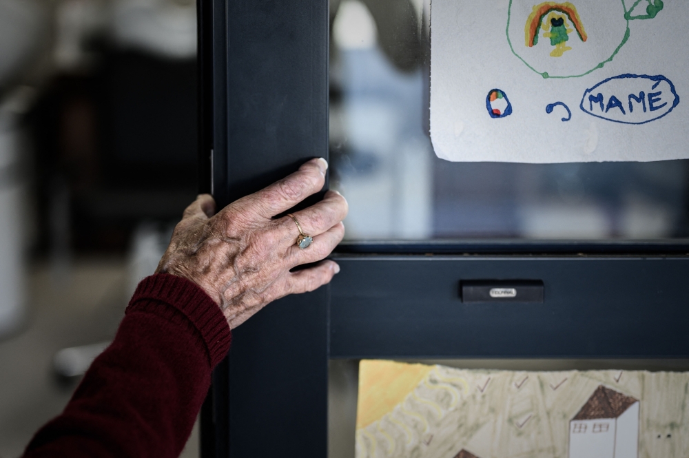 (Files) In this picture taken on September 9, 2020 an Alzheimer's patient stands at the entrance of the hairdressing salon in Dax, southwestern France. (Photo by Philippe Lopez/ AFP)