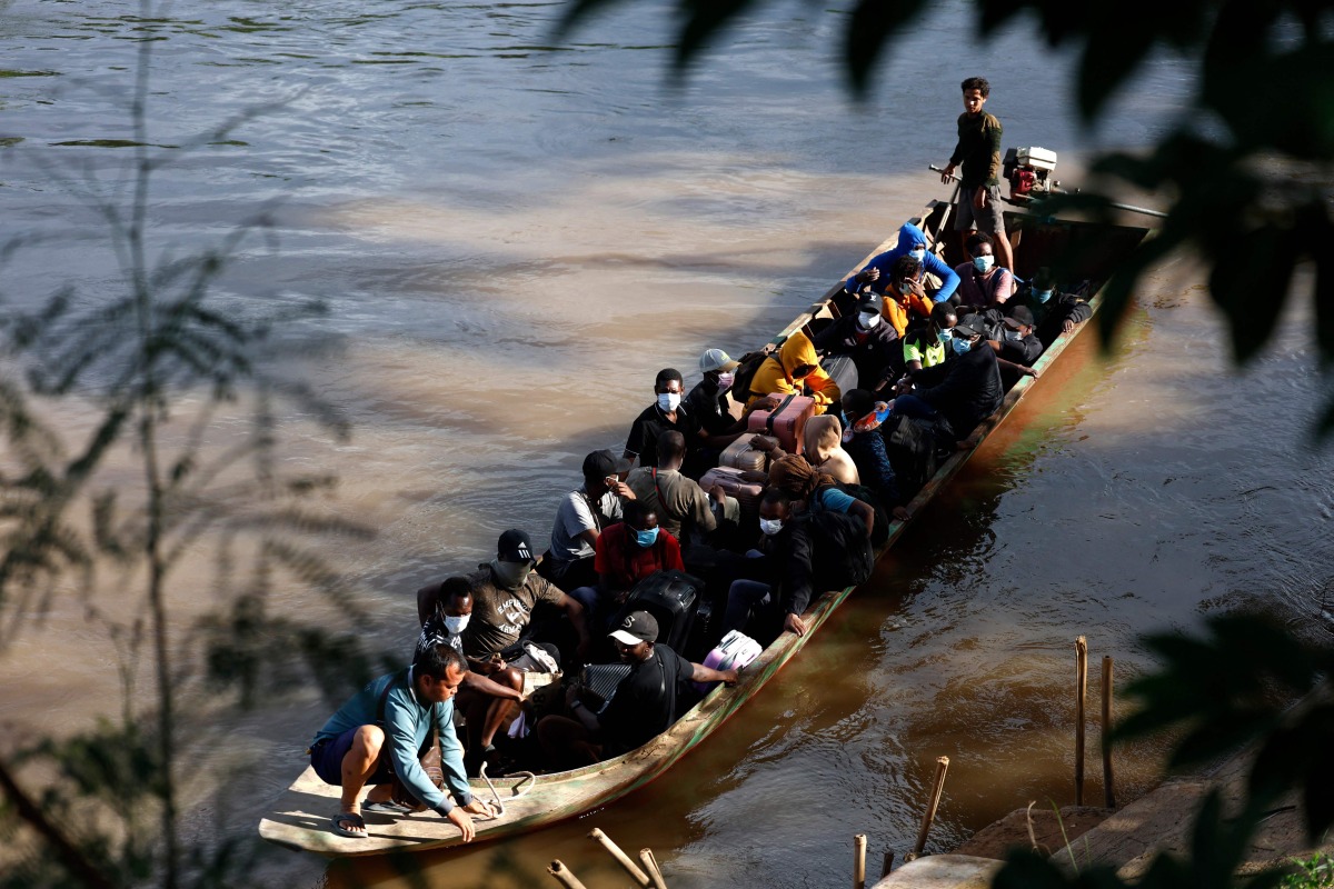 People from various countries, who were working in the KK Park compound in Myanmar, travel in a boat across the Moei river to cross over from Myanmar to Thailand, as seen from Mae Sot District, Tak Province area on October 24, 2025. (Photo by Sarot Meksophawannakul / THAI NEWS PIX / AFP)
