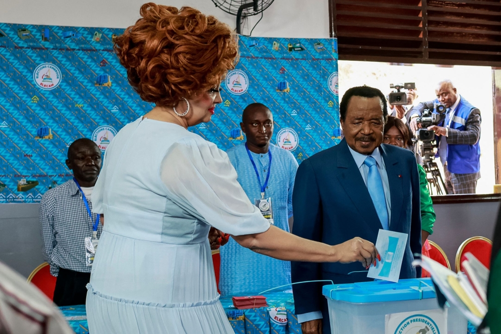 Paul Biya with wife Chantal Biya (L) cast their ballot at a polling station in Yaounde on October 12, 2025 during Cameroon's presidential election. Photo by Daniel Olomo / AFP