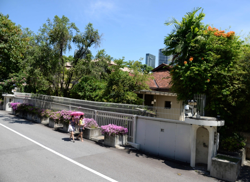 (Files) This picture taken on June 17, 2017, shows residents walking past the house of Singapore's late prime minister Lee Kuan Yew on 38 Oxley Road in Singapore.(Photo by Toh Ting Wei / AFP)
