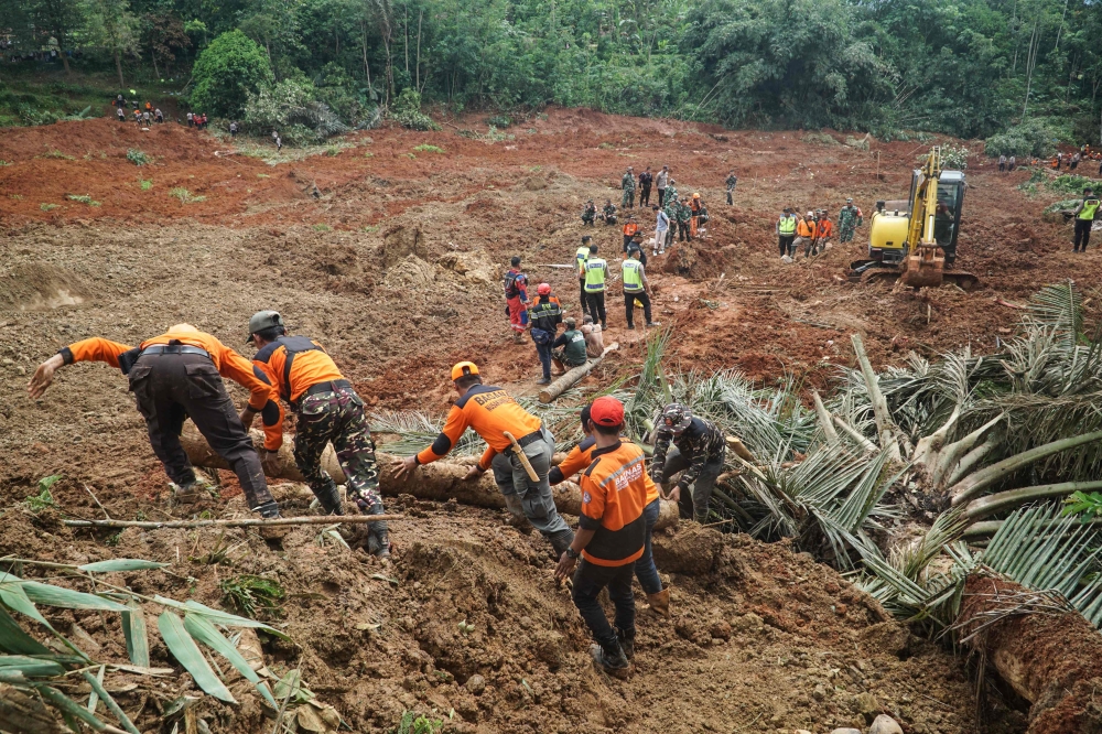 Rescuers search for survivors after a landslide buried some houses in Cibeunying village, Cilacap regency, Central Java, on November 14, 2025. Photo by Bakhtiar Rahman/ AFP