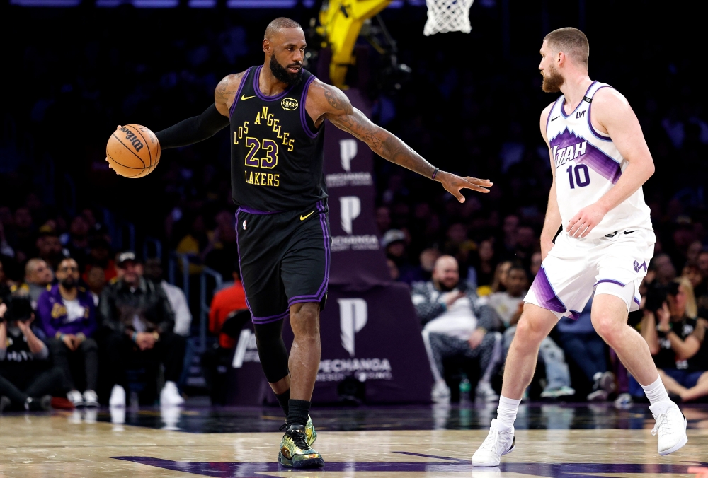 LeBron James #23 of the Los Angeles Lakers dribbles the ball against Svi Mykhailiuk #10 of the Utah Jazz during the second half on November 18, 2025 in Los Angeles, California. Ronald Martinez/Getty Images/AFP 