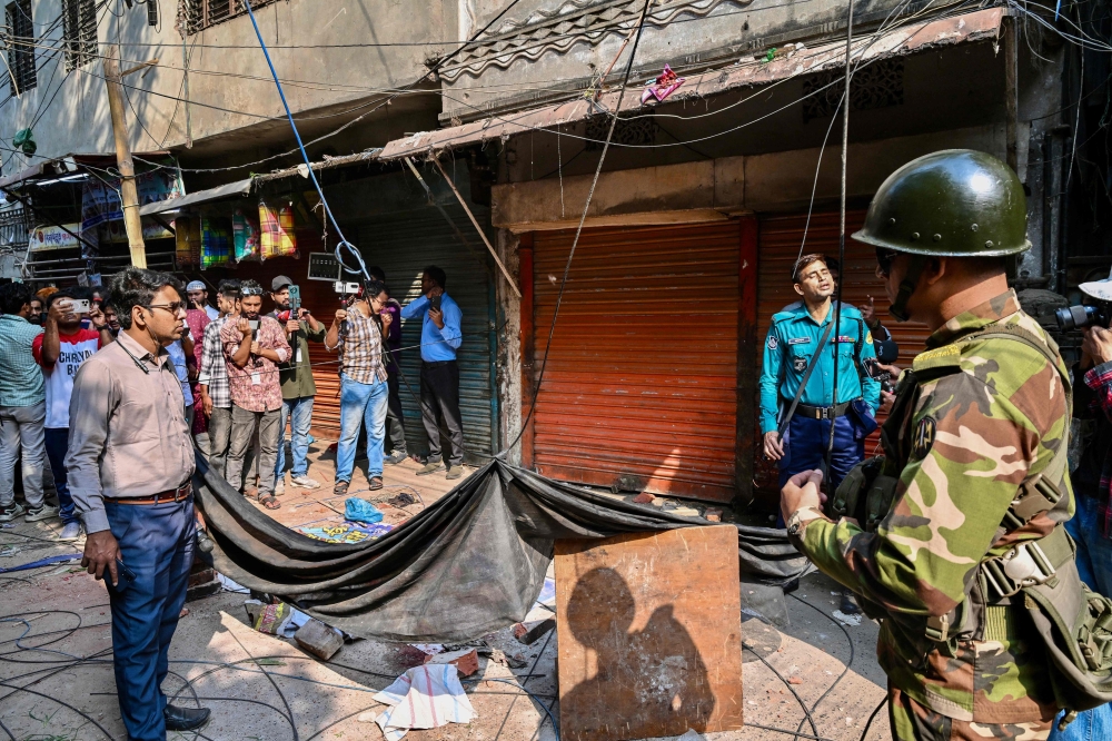 An army personnel stands guard near the rubble that fell from a damaged building following an earthquake in Old Dhaka on November 21, 2025. (Photo by Munir Uz Zaman / AFP)