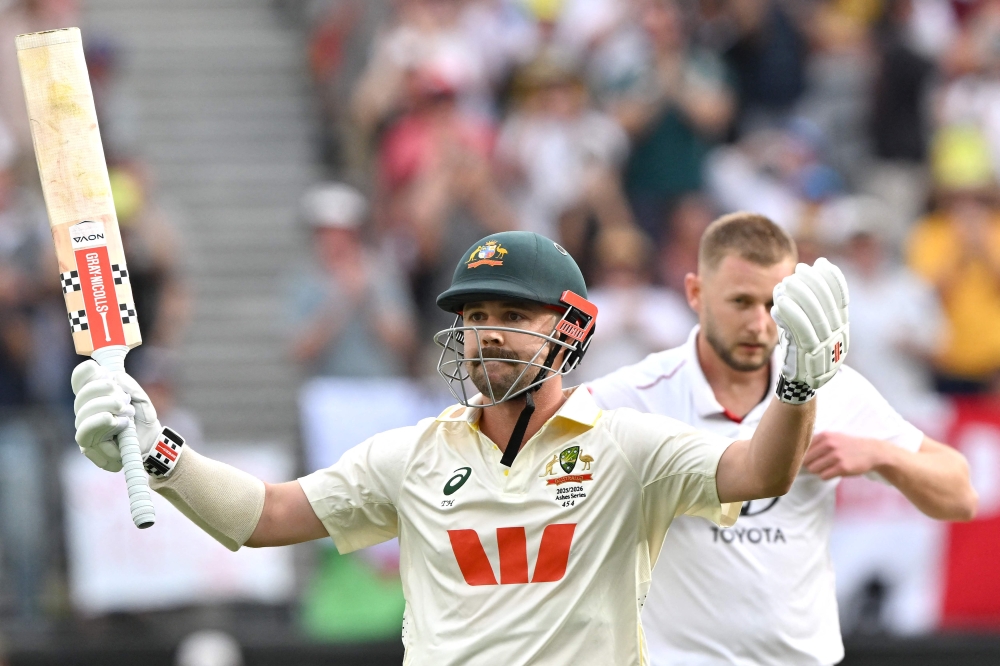 Australia's Travis Head celebrates reaching his century (100 runs) on day 2 of the first Ashes cricket Test match between Australia and England at Perth Stadium in Perth on November 22, 2025. (Photo by Saeed Khan / AFP)