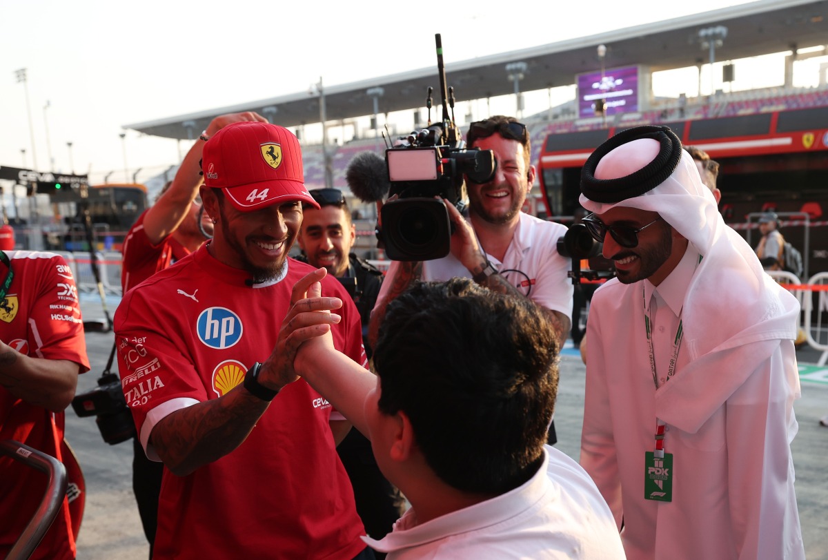 Ferrari's British driver Lewis Hamilton is greeted by a fan.