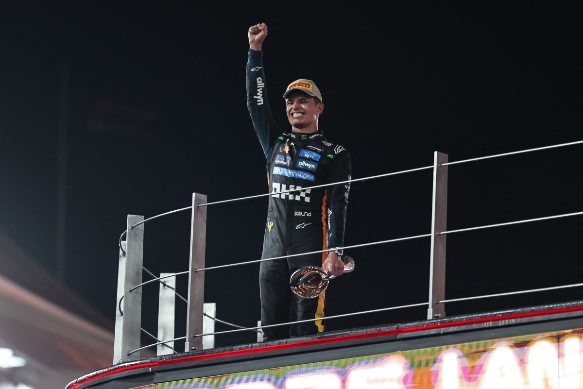 McLaren British driver Lando Norris celebrates with the trophy on the podium after finishing the race third to win the world championship title at the end of the Abu Dhabi Formula One Grand Prix at the Yas Marina Circuit in Abu Dhabi on December 7, 2025. (Photo by Fadel SENNA / AFP)