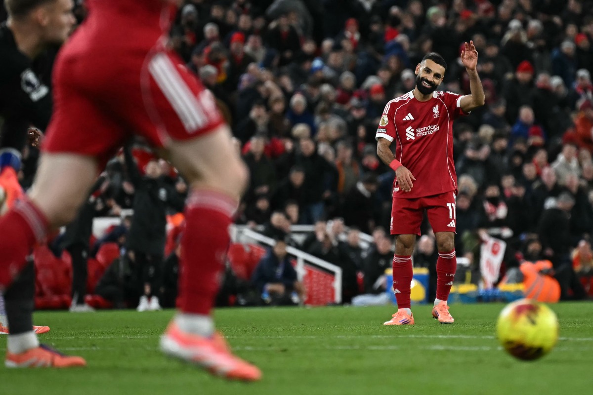 Liverpool's Egyptian striker #11 Mohamed Salah waves as he apologies to Liverpool's Dutch defender #04 Virgil Van Dijk (unseen) for a poor cross during the English Premier League football match between Liverpool and Brighton and Hove Albion at Anfield in Liverpool, north west England on December 13, 2025. (Photo by Paul ELLIS / AFP)