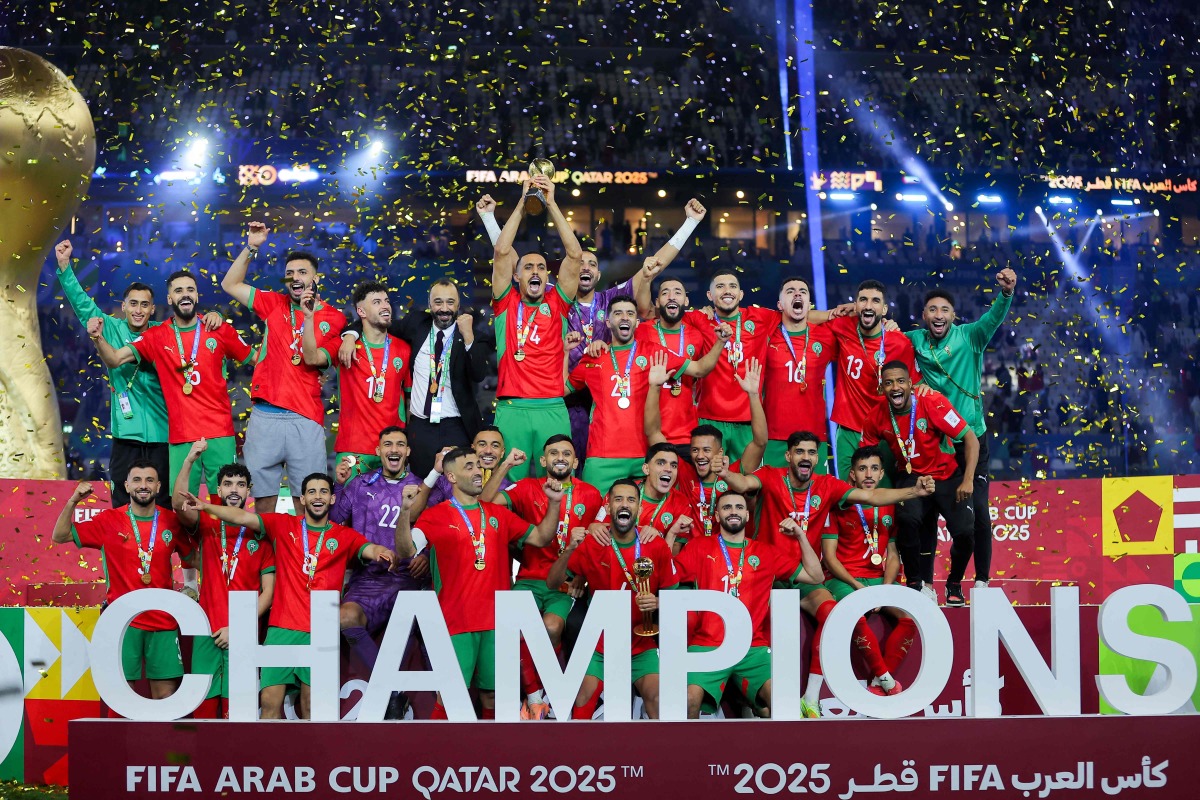 Morroco's players celebrate with the trophy after winning the FIFA Arab Cup 2025 final football match between Jordan and Morocco at the Lusail Stadium Stadium, in Lusail on December 18, 2025. (Photo by Karim JAAFAR / AFP)
