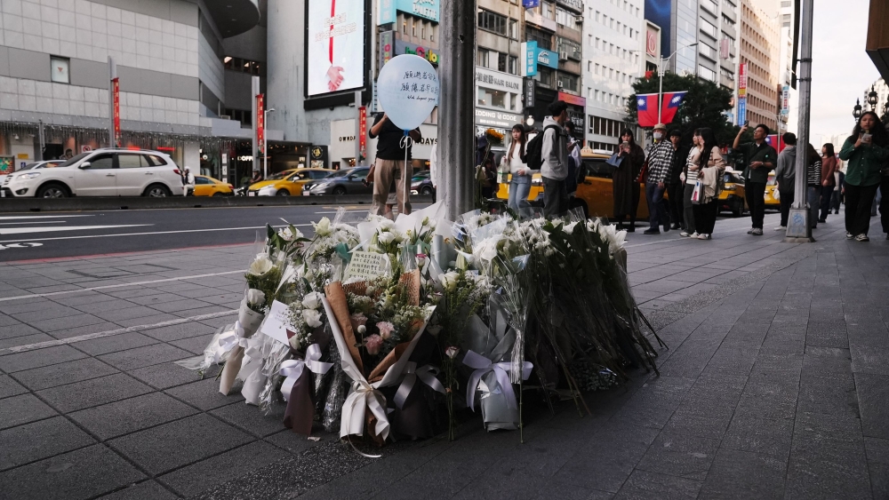 Flowers and notes from the public are laid for the victims of the metro attack outside a mall in Taipei on December 20, 2025. Taiwan's President Lai Ching-te pledged a full, public enquiry into a deadly metro stabbing attack as he visited victims in hospital on December 20. (Photo by Akio Wang / AFP)