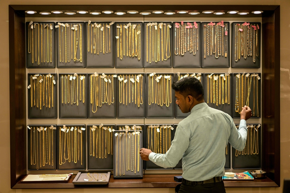(Files) A salesman arranges gold chains at a jewellery store on July 5, 2025. (Photo by R. Satish Babu / AFP)
