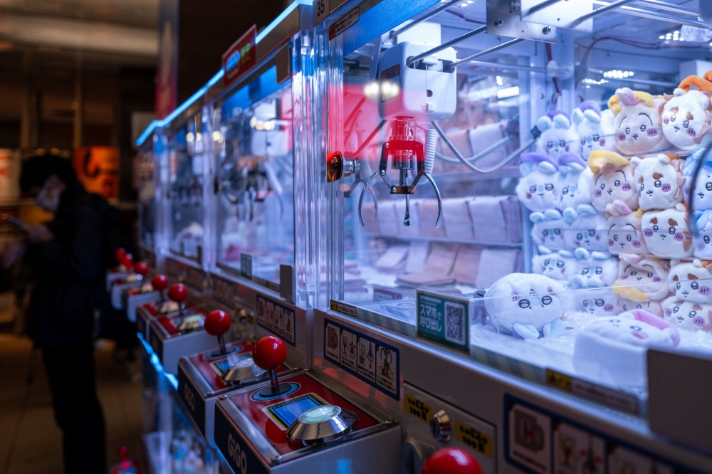 In this picture taken on November 22, 2025, stuffed toys are seen inside claw crane game machines inside a shop at Tokyo's Shinjuku district. (Photo by Philip Fong / AFP) 