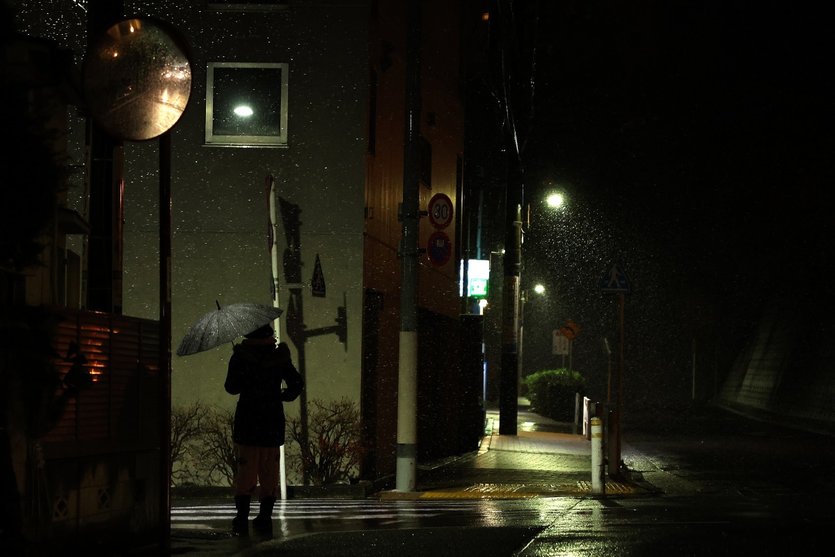 A woman walks on a street on the first snow day of 2026 in Tokyo, Japan, Jan. 2, 2026. (Xinhua/Jia Haocheng)