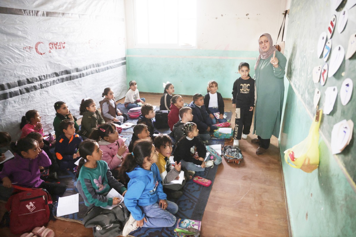 Palestinian children, many of whom are part of displaced families, sit on the floor as they attend class, at the UNRWA Deir Al-Balah Joint School, west of Deir Al-Balah. (AFP)