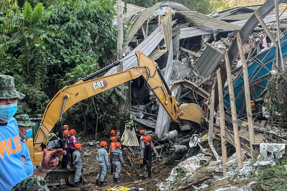 Search and rescue teams look for people after a landslide at the landfill in Barangay Binaliw, Cebu City on January 9, 2026. (Photo by Cheryl Baldicantos / AFP)
