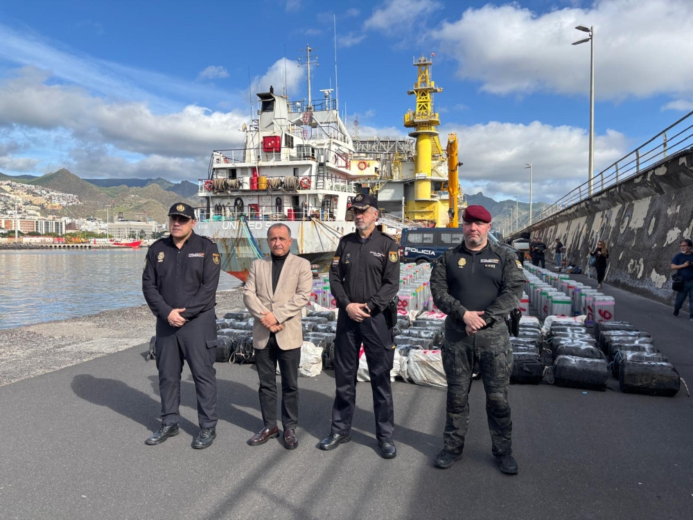 This undated handout photo released on January 12, 2026 by Spanish National Police shows Spanish police posing in front of some of the nearly 10 tons of cocaine seized on a cargo ship in Spain's Canary Islands. (Photo by Handout / Spanish National Police / AFP)