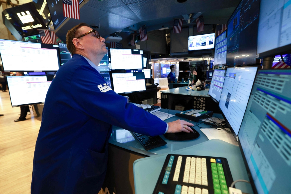 A trader works on the floor of the New York Stock Exchange (NYSE) at the opening bell in New York on January 23, 2026. (Photo by Timothy A. Clary / AFP)