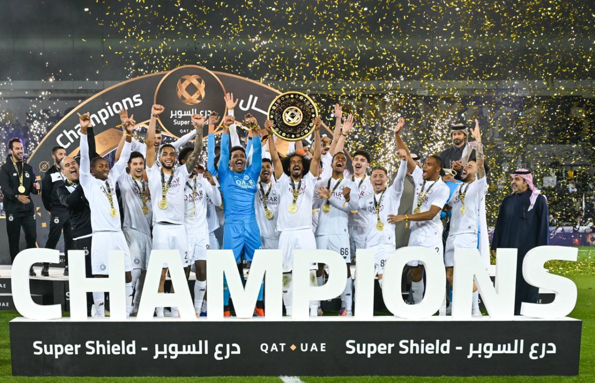 Akram Afif lifts the Super Shield as Al Sadd's players and officials celebrate their triumph.