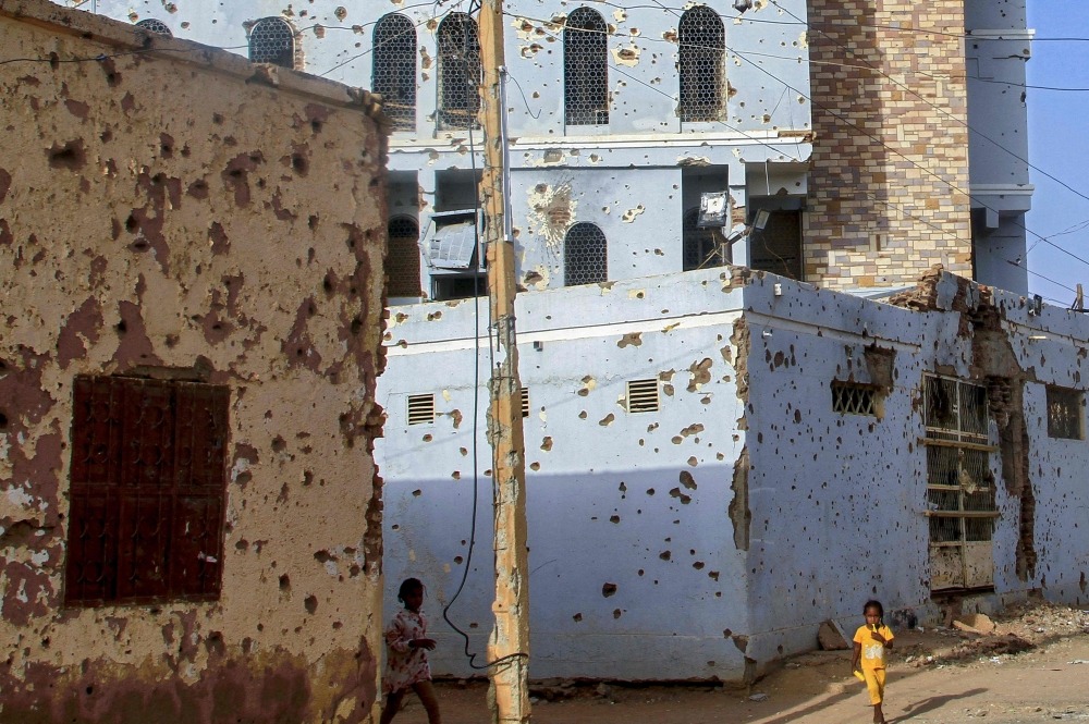 Children photographed near houses damaged with bullets in Omdurman. AFP file photo.