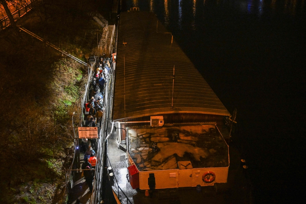 People wait in front the entrance to the cargo boat named 
