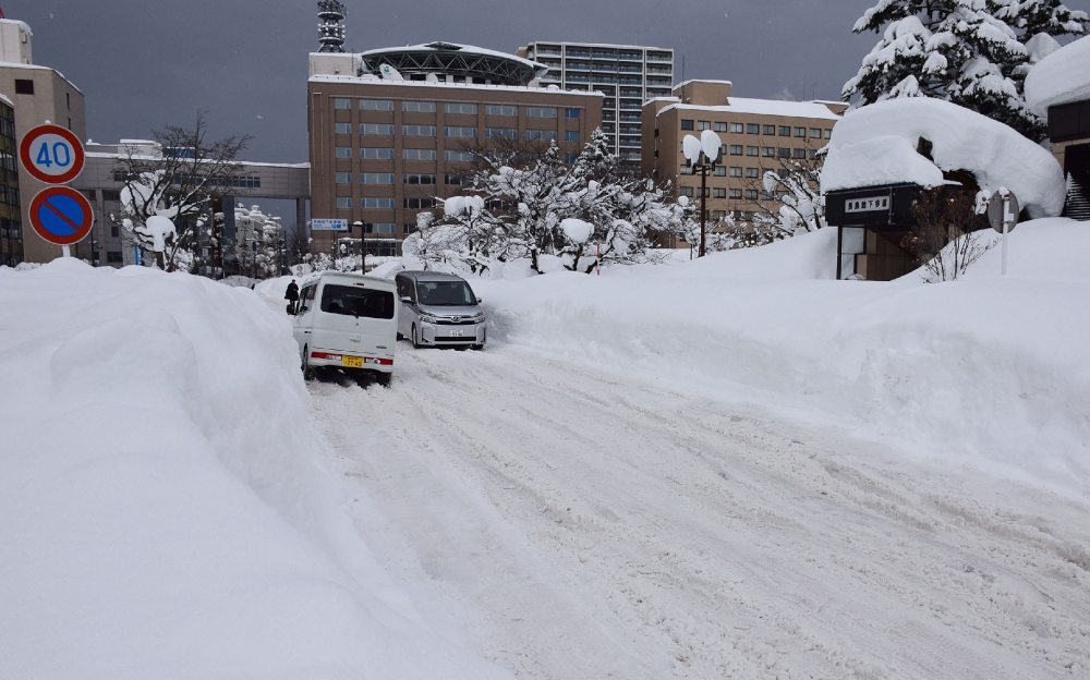 People commute along a snow-covered street in Aomori City, which is experiencing record-breaking heavy snowfall, on February 3, 2026. Photo by JIJI Press / AFP