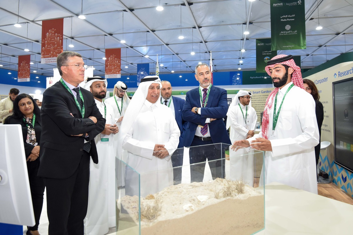 UDST President Dr. Salem Al-Naemi at the University's booth with other officials and participants. 