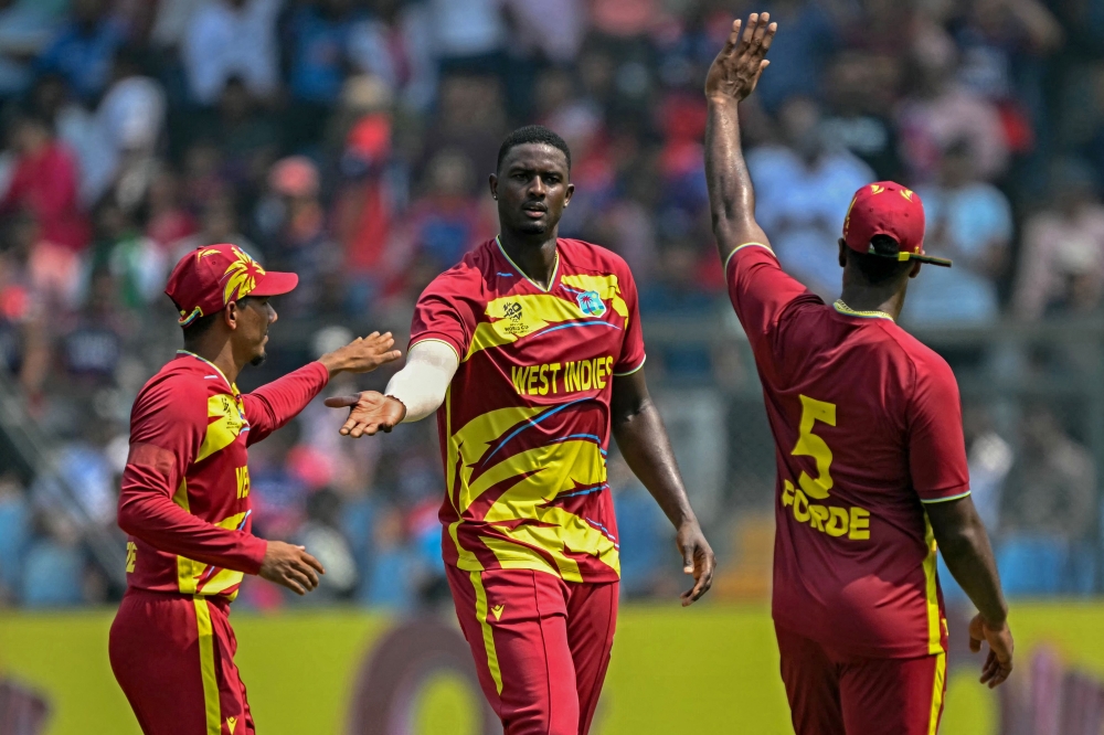 West Indies' Jason Holder (C) celebrates with teammates after taking the wicket of Nepal's Dipendra Singh Airee during the 2026 ICC Men's T20 Cricket World Cup group stage match between Nepal and West Indies at the Wankhede Stadium in Mumbai on February 15, 2026. (Photo by Indranil Mukherjee / AFP)
