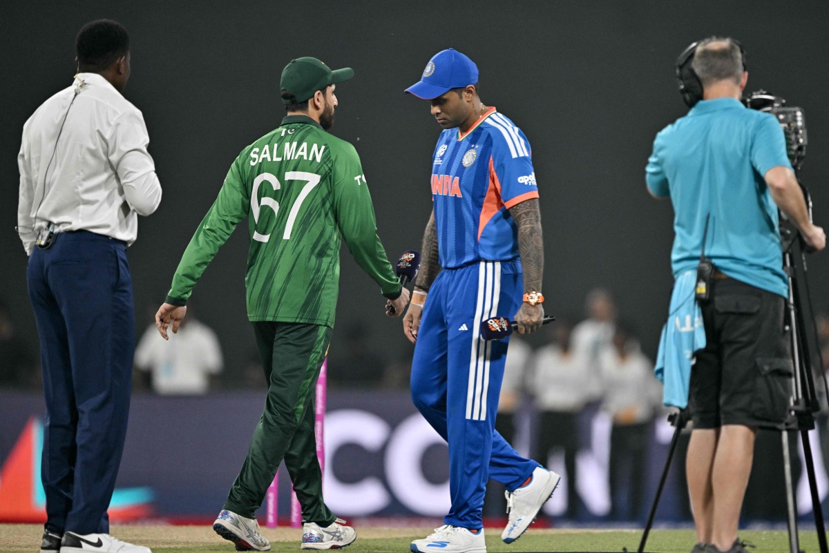 India's captain Suryakumar Yadav (2R) walks past his Pakistan counterpart Salman Agha (2L) after the toss before the start of the 2026 ICC Men's T20 Cricket World Cup group stage match between India and Pakistan at the R Premadasa Stadium in Colombo on February 15, 2026. (Photo by Manan VATSYAYANA / AFP)