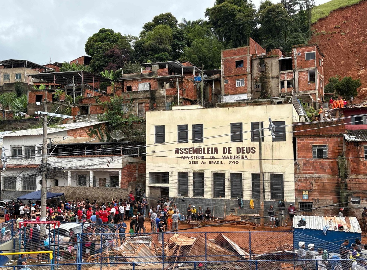 Rescue teams remove debris in search of victims of a landslide caused by heavy rains in the Barrio Parque Jardim Burnier neighbourhood in Juiz de Fora, Minas Gerais State, Brazil, on February 24, 2026. (Photo by Pablo PORCIUNCULA / AFP)