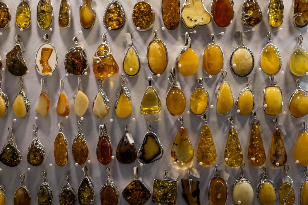 This photo shows jewellery made from natural Baltic amber, on sale at an amber shop on Mariacka Street in Gdansk, Poland on March 10, 2026. (Photo by Wojtek RADWANSKI / AFP)
