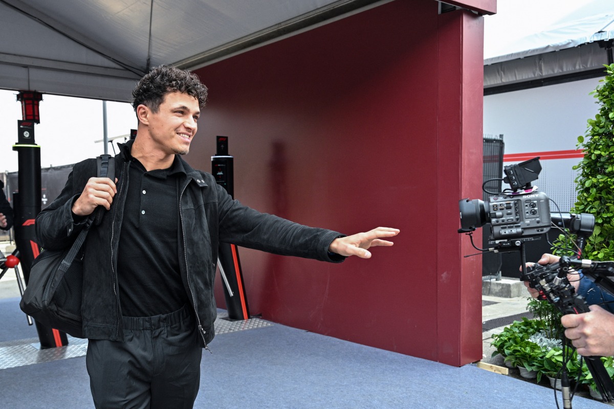 McLaren's British driver Lando Norris arrives to the paddock at the Shanghai International Circuit ahead of the Formula One Chinese Grand Prix in Shanghai on March 12, 2026. (Photo by Hector RETAMAL / AFP)
