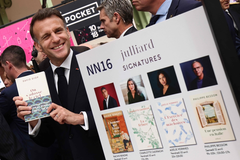 French President Emmanuel Macronvisits the Paris Book Fair at the Grand Palais in Paris on April 17, 2026. The fair, which runs until April 19, spotlights comic books as its central theme. (Photo by Teresa SUAREZ / POOL / AFP)