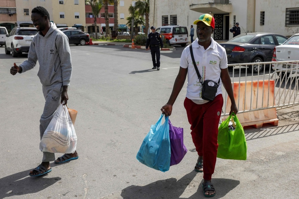 Senegal football supporters walk with their personal belongings after being released from Al Arjat 2 prison in Sale on April 18, 2026.(Photo by Abdel Majid BZIOUAT / AFP)
 