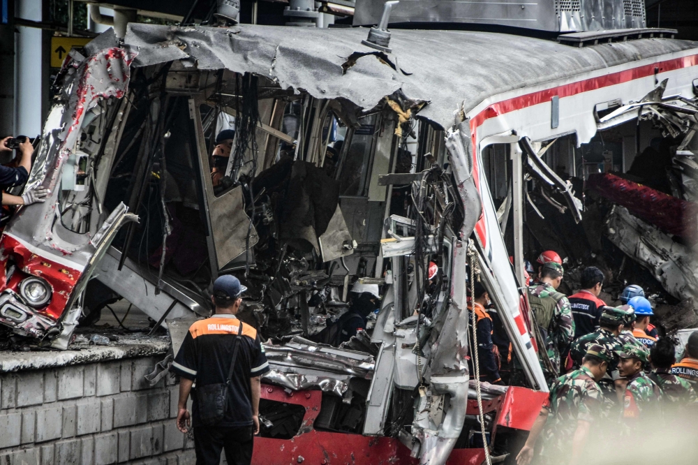 INDONESIA-RAIL-ACCIDENT
Workers clear debris at the train collision site after the locomotive of a passenger train pierced through the rear car of a commuter train at Bekasi Timur Station in Bekasi, West Java on April 28, 2026. 
(Photo by Rezas / AFP)