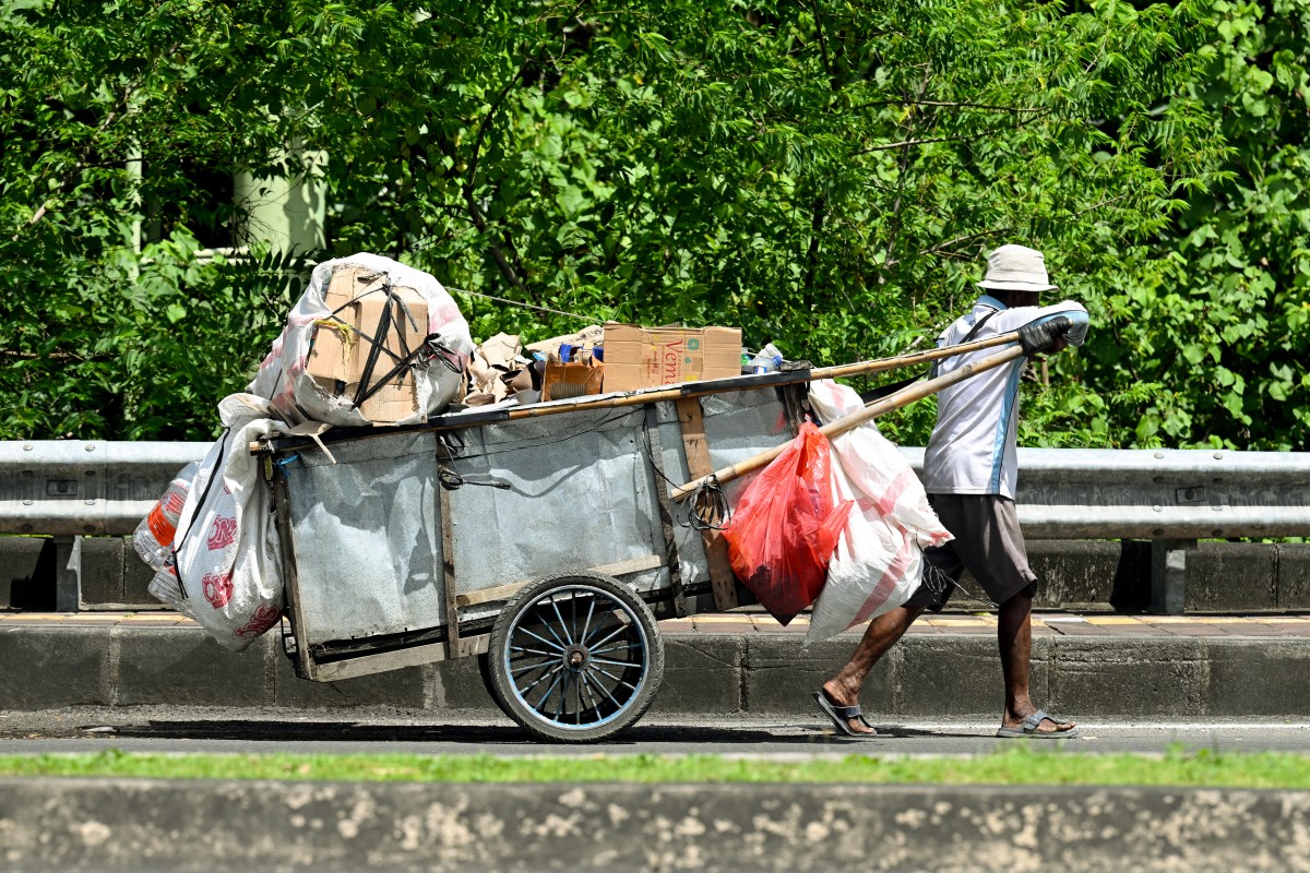 A door-to-door waste collector pushes his cart in front of a house in Jakarta on May 4, 2026. (Photo by Bay Ismoyo / AFP)
