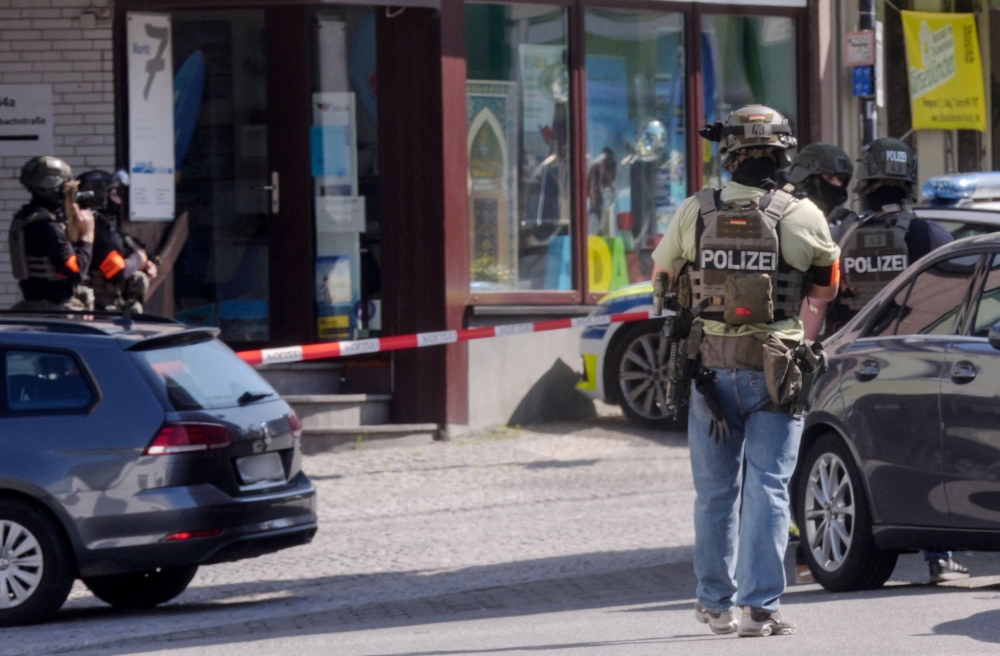 Police stand in a cordoned off area near a bank where suspects have taken multiple hostages in the western German town of Sinzig, on May 8, 2026. (Photo by Thomas Frey / DPA / AFP) 