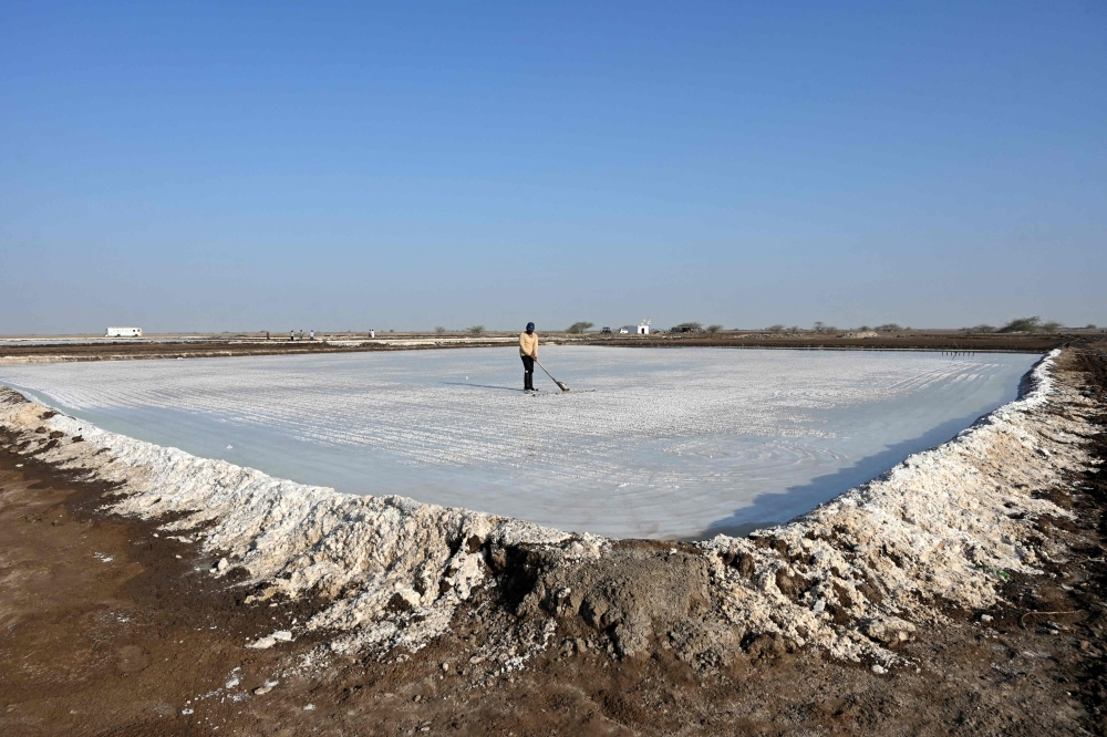 A worker harvests salt at the Little Rann of Kutch (LRK) region of Gujarat on April 29, 2026. (Photo by Shammi Mehra / AFP) 