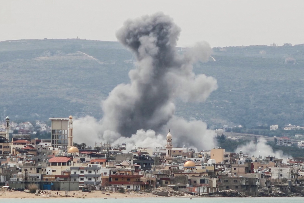  A photograph taken from the southern area of Tyre shows smoke rising from the site of an Israeli airstrike that targeted the area of Ras Al-Ain on May 12, 2026. (Photo by KAWNAT HAJU / AFP)
