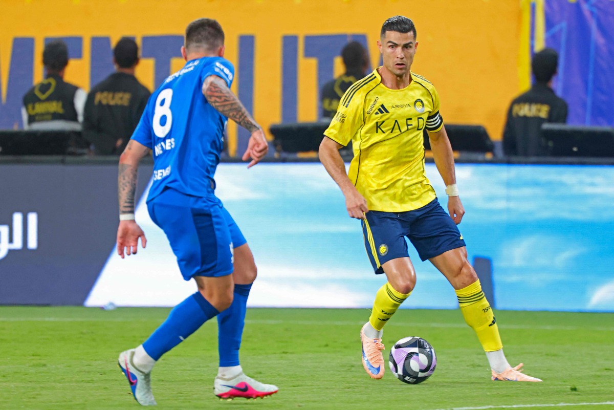 Al Nassr's Portuguese forward #07 Cristiano Ronaldo fights for the ball with with Al Hilal's Portuguese midfielder #08 Ruben Neves during the Saudi Pro League football match between Al Nassr and Al Hilal at King Fahd Sports City Stadium in Riyadh on May 12, 2026. (Photo by Fayez NURELDINE / AFP)