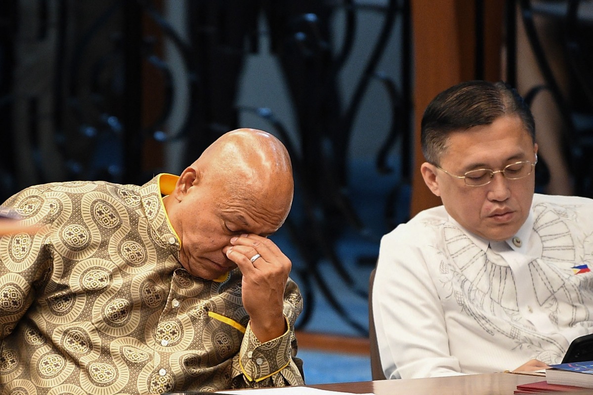 Philippine Senator Ronald dela Rosa (L) gestures next to colleague Christopher Go during a Senate plenary session on the third day of him holed up in the Senate building in Manila on May 13, 2026. Photo by TED ALJIBE / AFP