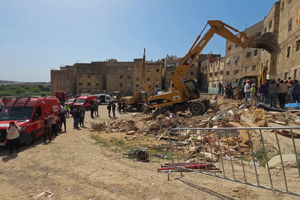 Rescuers search through the rubble of a four-storey building that collapsed overnight in the Moroccan city of Fes, on May 21, 2026. (Photo by Abdelmajid Bziouat / AFP)
