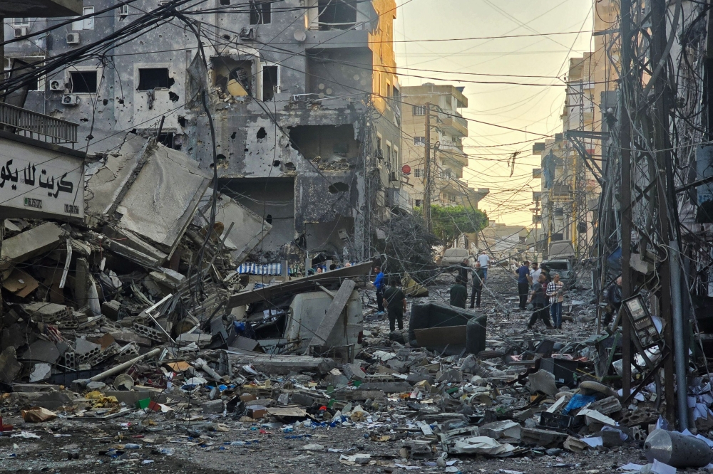 People inspect the site of an Israeli strike in the southern Lebanese coastal city of Tyre on May 23, 2026. (Photo by Kawnat Haju/ AFP)