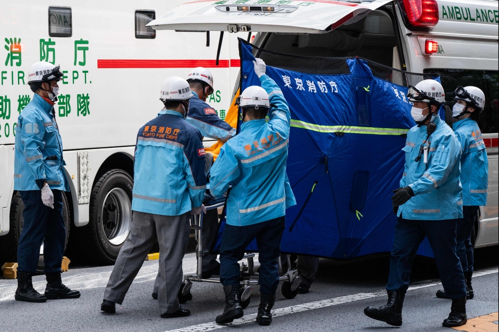 A person is taken on a stretcher to an ambulance by paramedics at the Ginza 6 Shopping Center in Tokyo on May 25, 2026, after an individual allegedly sprayed a substance in the area. (Photo by Andrew Caballero-Reynolds / AFP) 