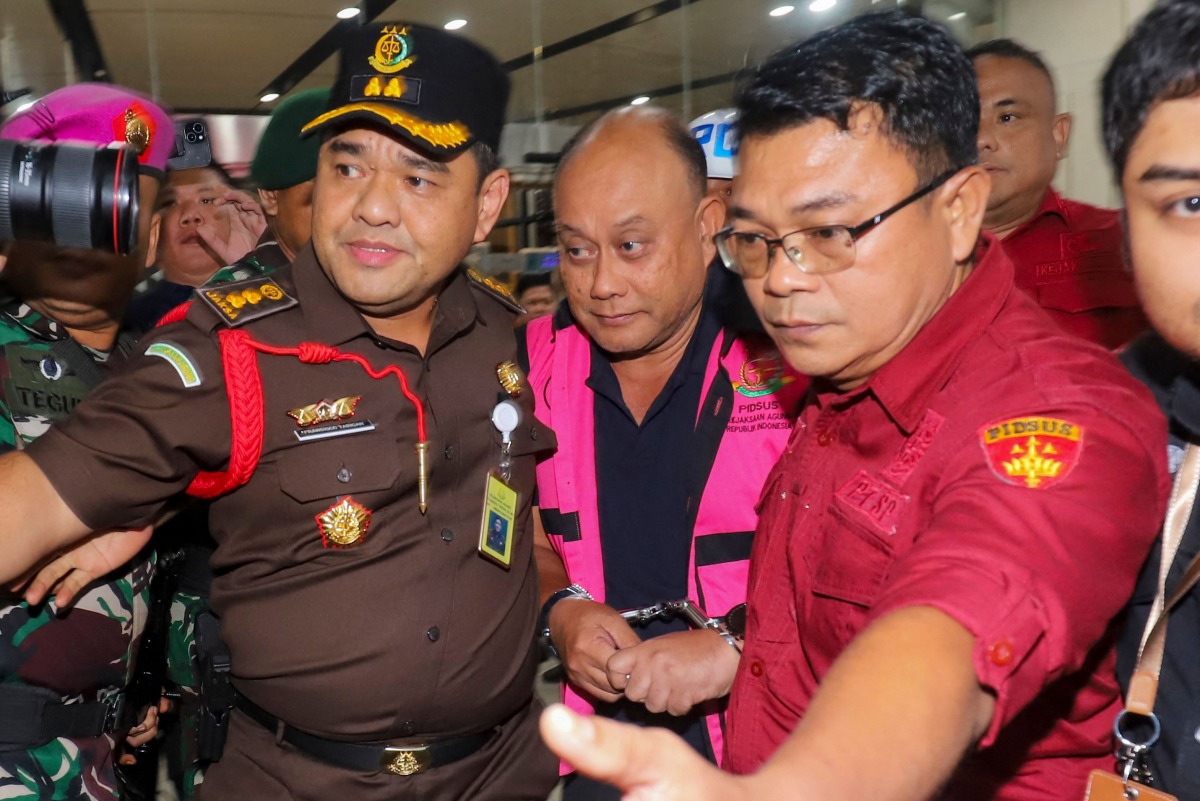 Dadan Hindayana (C), former head of Indonesia's free school meals programme, is escorted by officers from the Attorney General's Office and Indonesian military personnel as he leaves the Attorney General's Office building in Jakarta on June 3, 2026, following questioning over alleged misappropriation in the implementation of the programme. Photo by Diyah Nasution / AFP