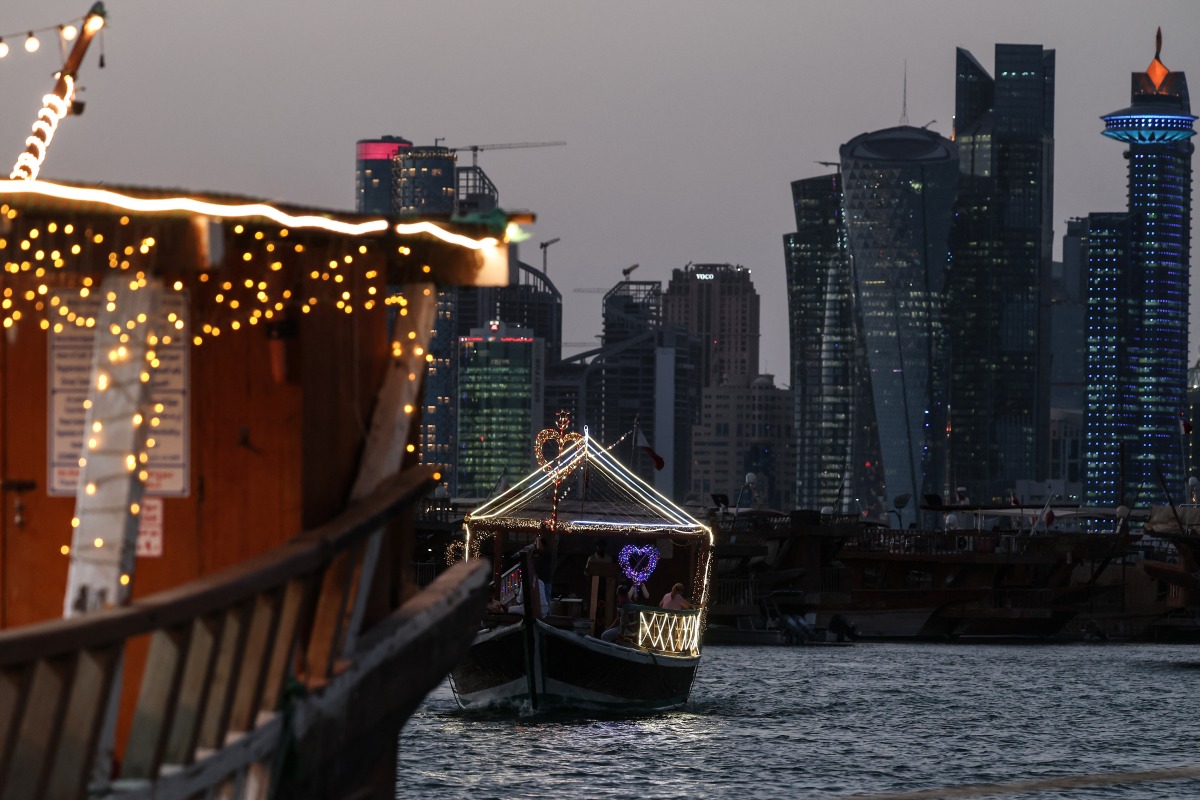 Traditional wooden boats are pictured against the backdrop of illuminated skyscrapers along the Corniche promenade in Doha on May 31, 2026. (Photo by Karim JAAFAR / AFP)
