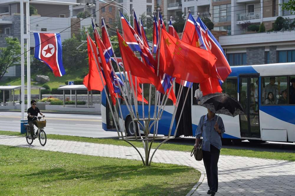 The national flags of North Korea and China are displayed on a street in Pyongyang on June 8, 2026 (Photo by Kim Won Jin / AFP)