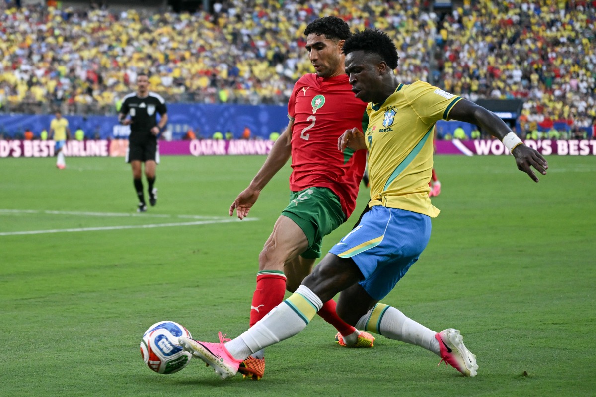 Morocco's defender #02 Achraf Hakimi adn Brazil's forward #07 Vinicius Junior fight for the ball during the 2026 World Cup Group C football match between Brazil and Morocco at the New York/New Jersey Stadium in East Rutherford on June 13, 2026. (Photo by Mauro PIMENTEL / AFP)