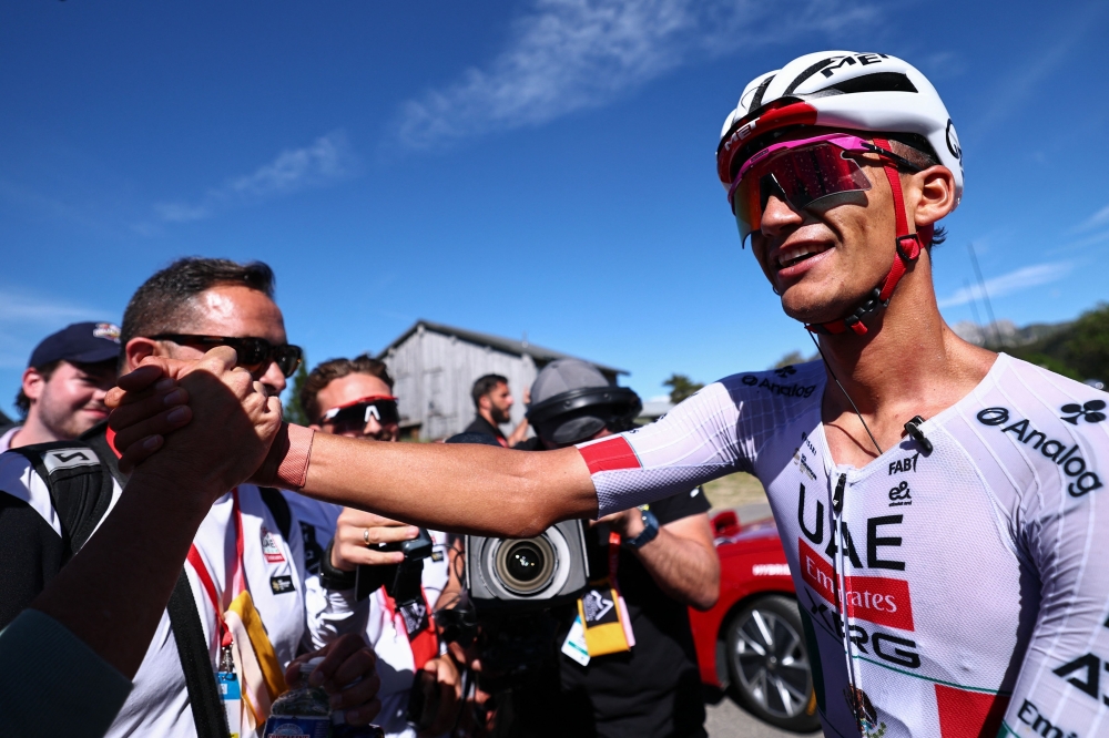 UAE Team Emirates XRG's Mexican rider Isaac Del Toro Romero celebrates winning the 8th and final stage of the Tour Auvergne-Rhone-Alpes cycling race, 120,1km between Beaufort and Plateau de Solaison, in the French Alps on June 14, 2026. (Photo by Anne-Christine POUJOULAT / AFP)