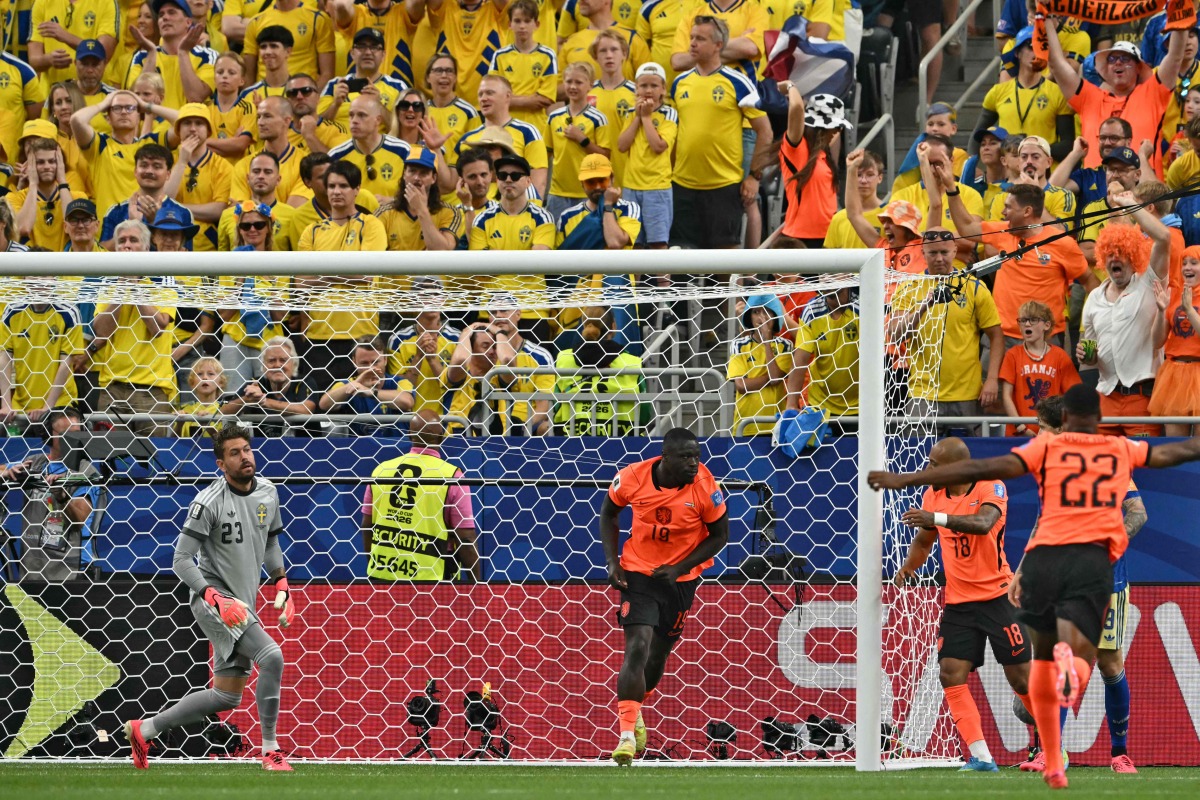 :Netherlands' forward #19 Brian Brobbey (C) celebrates next to Sweden's goalkeeper #23 Kristoffer Nordfeldt (L) after scoring a goal during the 2026 World Cup Group F football match between the Netherlands and Sweden at the Houston Stadium in Houston on June 20, 2026. (Photo by RONALDO SCHEMIDT / AFP)